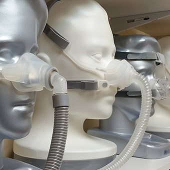 Wooden models wearing different CPAP masks