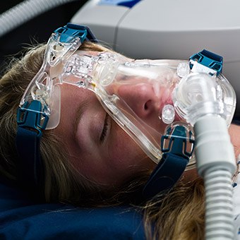 Woman with full face CPAP mask in place