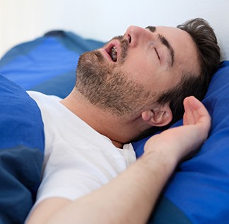 Man in bed sleeping with mouth open