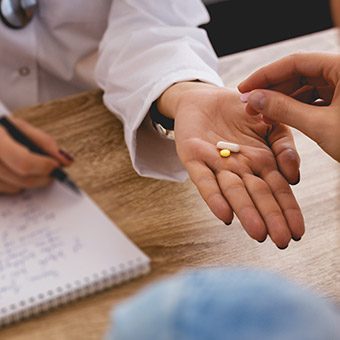 Doctor handing pills to patient