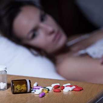 Frustrated woman looking at sleeping pills
