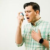 A man using an inhaler because of his asthma