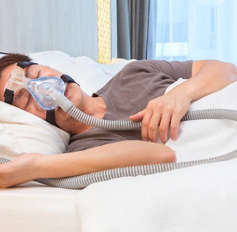 A middle-aged man wearing a CPAP device to manage his sleep apnea