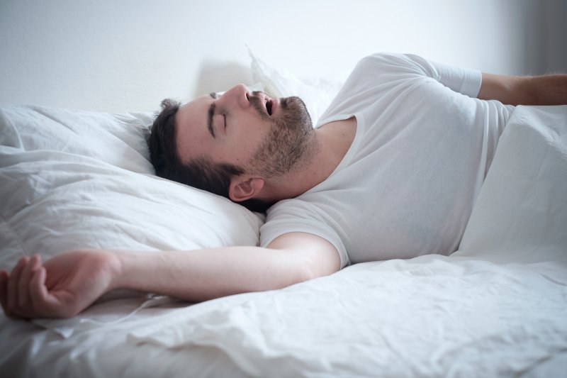 man asleep in bed with his mouth open