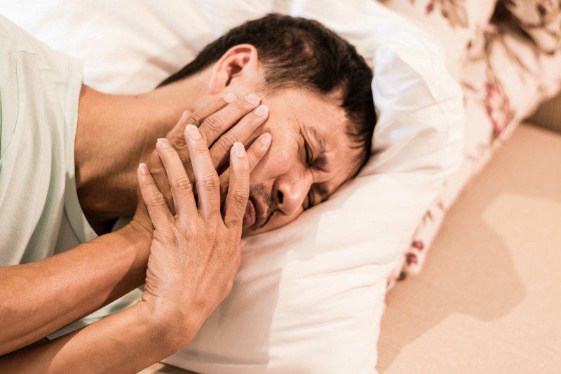 man in bed experiencing TMD pain 