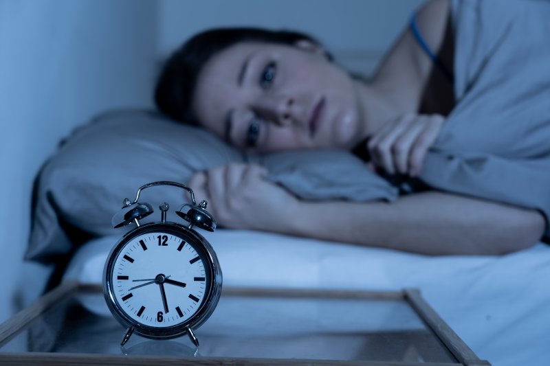 woman lying awake at night feeling anxious